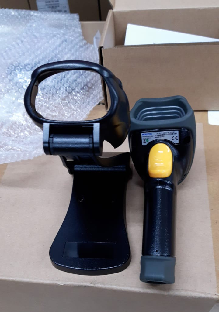 Barcode scanner with a yellow button on a cardboard box
